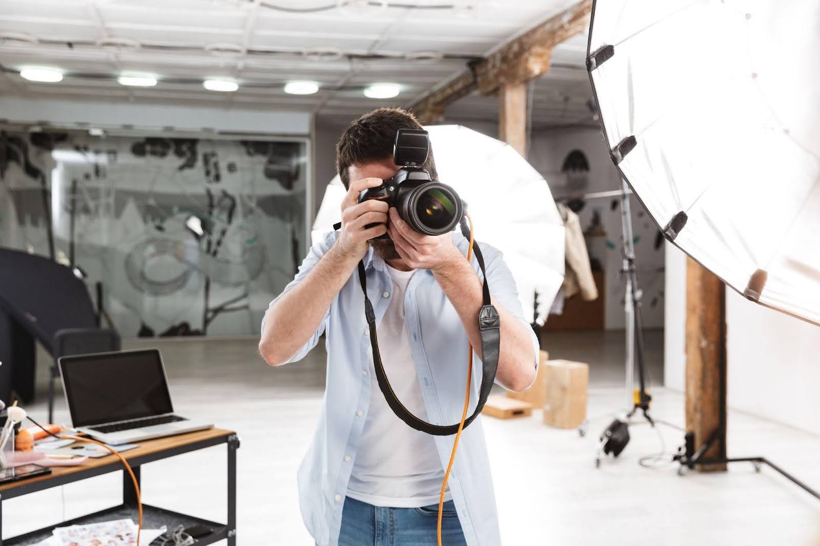 A man captures a moment with a camera in a well-lit photography studio setting