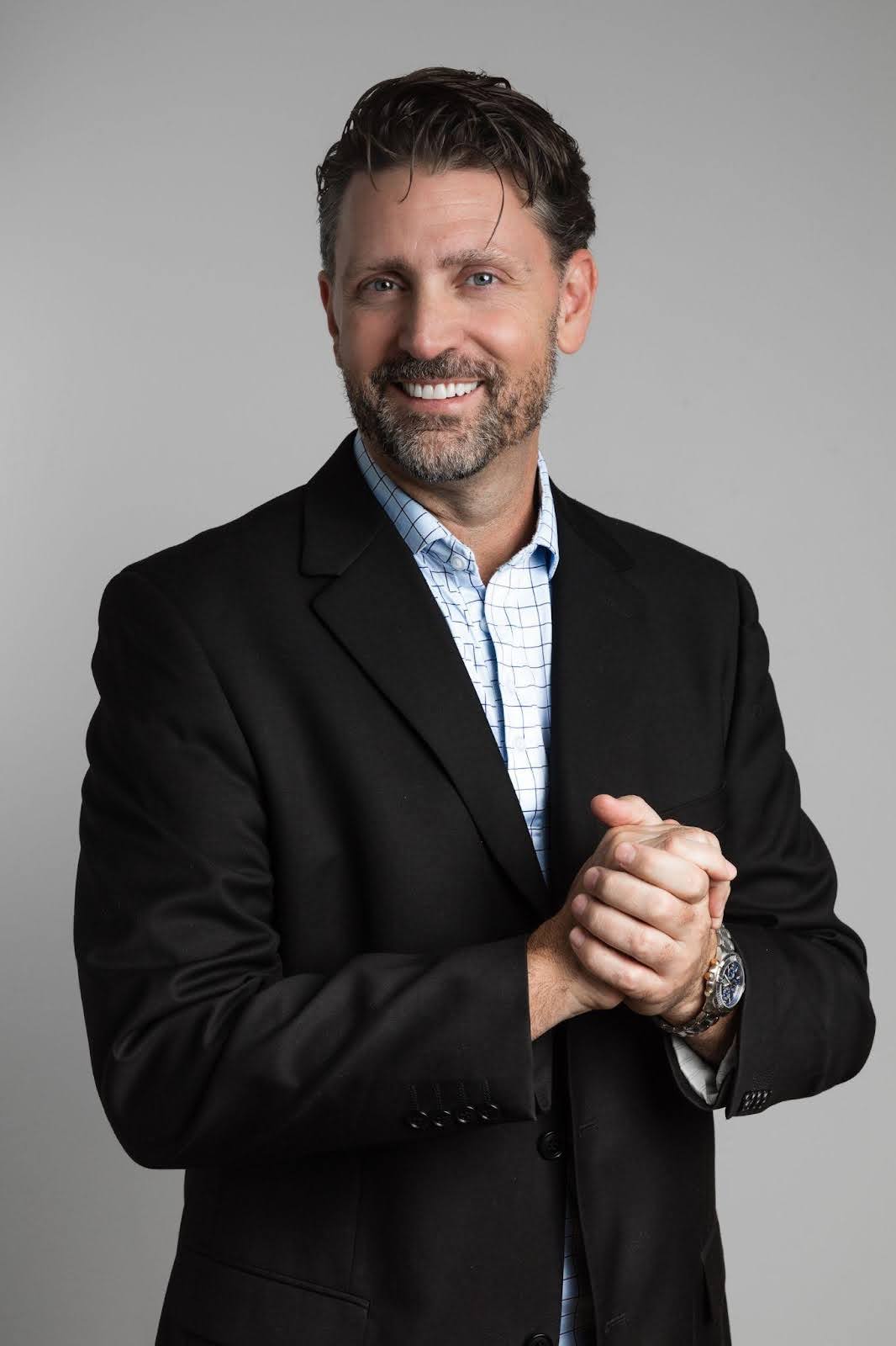 A smiling man in a suit and tie embodies professionalism and charm