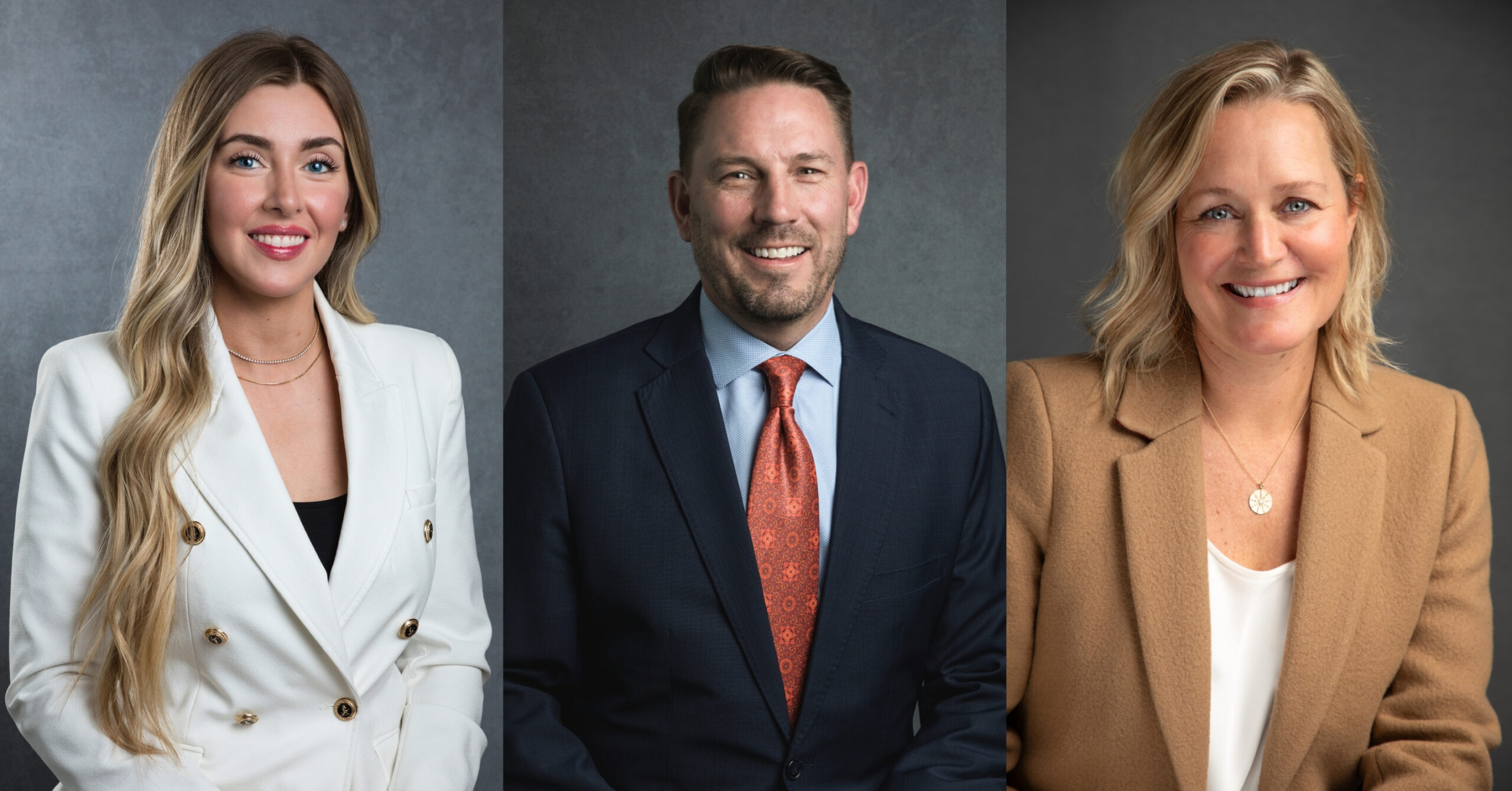 Three business people, dressed professionally, smile for the camera,