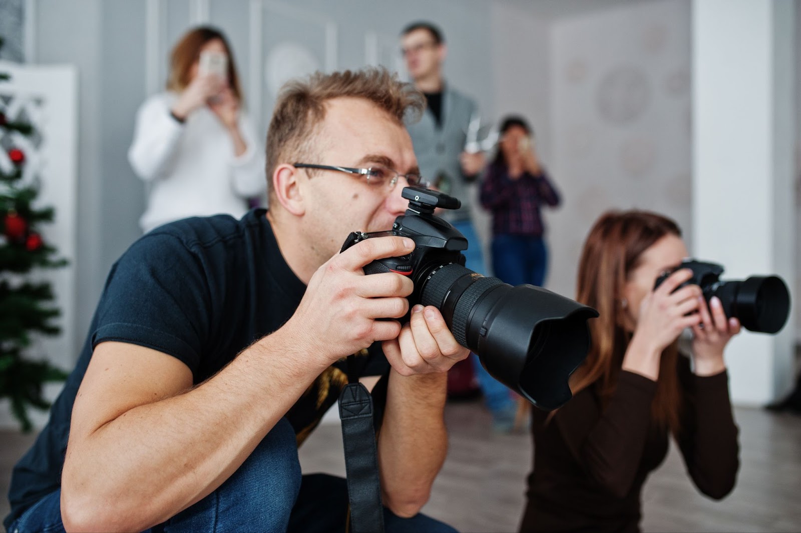 A man capturing a professional image with a camera, showcasing corporate photography expertise in headshot creation.