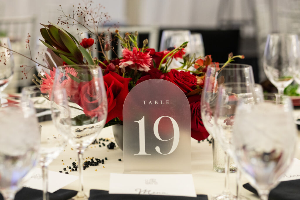 Holiday table setting at corporate event with red roses.