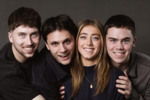 Four young people smile and pose together for a cheerful group photo